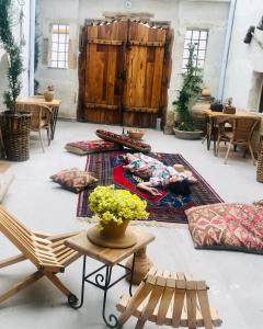 a room with several tables and chairs on a rug at terracota hotel in Nevsehir