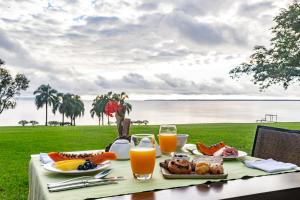 una mesa con comida y vistas al agua en Puerto Valle Hotel de Esteros en Puerto Valle