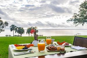 uma mesa com comida com vista para a água em Puerto Valle Hotel de Esteros em Puerto Valle