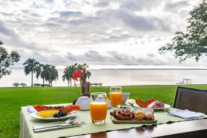 una mesa con comida y vistas al agua en Puerto Valle Hotel de Esteros, en Puerto Valle