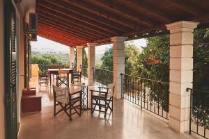 a patio with chairs and tables on a balcony at The Guund House in Xanthátai