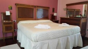 a bedroom with a bed with two towels on it at Corte Posta B&B in Mantova