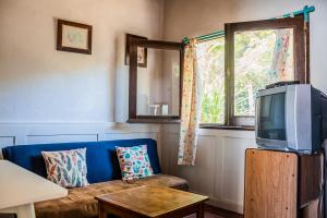 a living room with a blue couch and a tv at Cabañas Virazon Aguas Dulces in Aguas Dulces