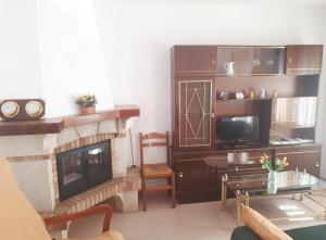 a living room with a fireplace and a tv at Casa Tormes in El Barco de Ávila