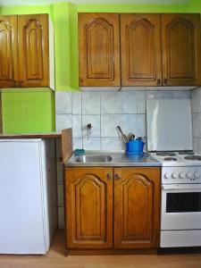 cocina con armarios de madera y horno de fogón blanco en Stan na dan Foča, en Foča