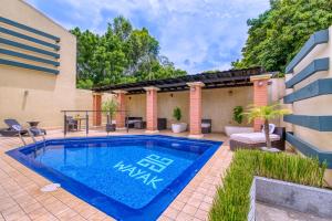 una piscina en un patio con una casa en Wayak Hotel en Managua