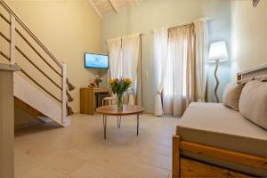 a room with a bed and a table with a vase of flowers at Archontissa House in the Old Town in Rethymno Town +25 photos