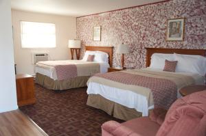 um quarto de hotel com duas camas e um sofá em Sara Glen Motel - Saratoga Springs-Glens Falls em Saratoga Springs
