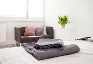 uma pilha de toalhas sentadas numa cama com um sofá em Super komfortowe mieszkanie - MTB Narty Góry Sowie em Dzierżoniów