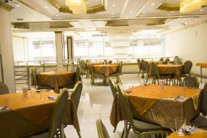 a dining room with tables and chairs with yellow table cloth at Swan Hotel in Lima