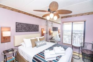 1 dormitorio con 1 cama grande y ventilador de techo en Beacher's Lodge en Crescent Beach