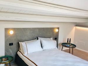 a bedroom with a white bed with two side tables at Alma White Suite in Siracusa