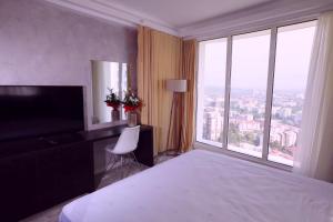 スコピエにある33rd floor luxury apartment spa & fitnessのベッドと大きな窓があるホテルの部屋 +17枚の写真