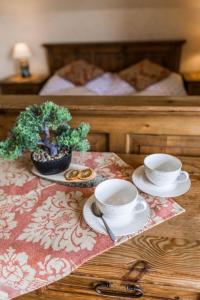 einen Tisch mit zwei Tassen und einem Teller Essen in der Unterkunft Willa Cetynka in Zakopane