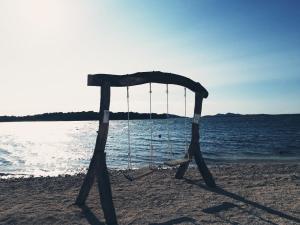 a swing on the beach near the water at Apartments Leonarda in Murter