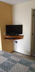 a flat screen tv on a wall in a bedroom at ApartHotel - Praia Mansa 1 e 2 Qtos in Fortaleza
