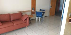 ein Wohnzimmer mit einem Sofa, einem Tisch und Stühlen in der Unterkunft ApartHotel - Praia Mansa 1 e 2 Qtos in Fortaleza