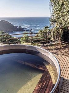a wooden bridge over a body of water near the ocean at Hostería La Casa del Mar in Bahía Mansa +80 photos
