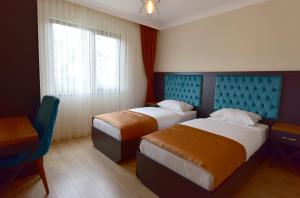 um quarto de hotel com duas camas e uma janela em İnanlar Airport Residence em Trabzon
