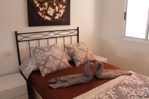 a bed with two towels sitting on top of it at Casa Romantica de Balcon de Amadores in Amadores +39 photos