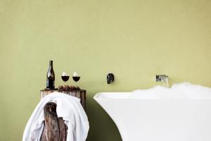 a bathroom with a sink and two glasses of wine at Mt Hay Retreat in Berry