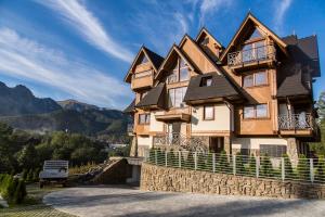 Polana Szymoszkowa Ski Resort - Chamerion Apartments في زاكوباني: منزل على تلة مع الجبال في الخلفية