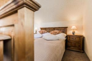 Schlafzimmer mit einem Bett mit weißer Bettwäsche und Kissen in der Unterkunft Willa Cetynka in Zakopane