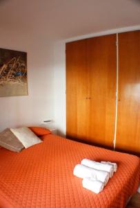 Un dormitorio con una cama naranja con toallas. en Torre Augusta en Córdoba