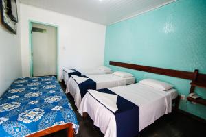 Un grupo de 4 camas en una habitación en Pousada Sitio Paraiso, en Itacaré