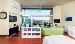 Mt Hay Retreat في بيري: غرفة نوم مع أريكة خضراء ونافذة كبيرة
