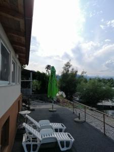 a patio with a green umbrella and a table and chairs at Holiday home Ramovic in Virpazar