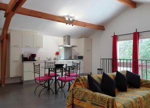 a living room with a couch and a table with chairs at La Cazarelle in Saint-Jean-de-Cuculles