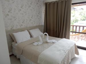 a bedroom with a bed with a swan on it at NANNAI RESIDENCE in Porto De Galinhas