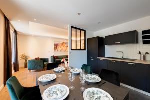 - une cuisine et une salle à manger avec une table et des chaises dans l'établissement LE MIRAGE - Annecy Centre - Appartement de luxe - V-RENT, à Annecy