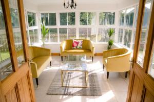 sala de estar con 2 sillas, mesa y ventanas en Farmleigh House,, en Donegal