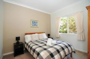 a bedroom with a bed and a window at Bimbadeen Comfortable country styled house in Kangaroo Valley