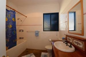 a bathroom with a sink and a tub and a toilet at Seahaven Beach House - Shellharbour in Shellharbour