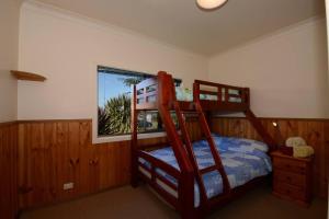 a bedroom with two bunk beds and a window at Seahaven Beach House - Shellharbour in Shellharbour