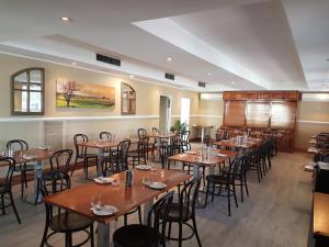 Mid City Motor Inn Singleton في سينغل تون: غرفة طعام مع طاولات وكراسي خشبية