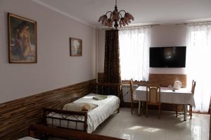 a bedroom with a table and a bed and a dining room at Hotelik Niedżwiadek in Radzyń Podlaski