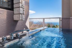 una piscina con vista su una casa di the salon 伊豆高原 Hotels & Resort a Ito