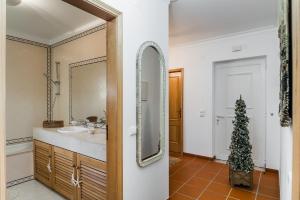 a bathroom with a sink and a mirror at Burgo Dom Afonso V Golf & Beach Resort in Casal da Lagoa Seca +36 photos