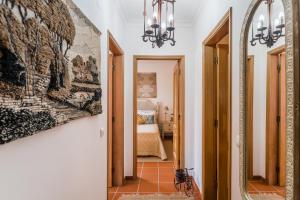 - un couloir avec une chambre dotée d'un lit et d'un miroir dans l'établissement Burgo Dom Afonso V Golf & Beach Resort, à Casal da Lagoa Seca