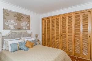a bedroom with a large bed with wooden shutters at Burgo Dom Afonso V Golf & Beach Resort in Casal da Lagoa Seca