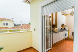 een keuken met een schuifdeur naar een balkon bij Burgo Dom Afonso V Golf & Beach Resort in Casal da Lagoa Seca