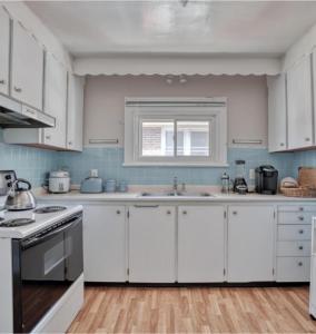 a white kitchen with white cabinets and a sink at Elcho explOre Ottawa in Ottawa