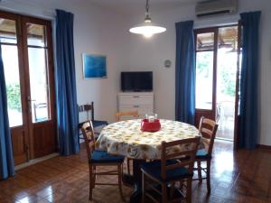a dining room with a table and chairs and a television at Terrazza sul Mare holidays with experiences in Lipari
