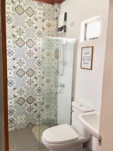 a bathroom with a shower with a toilet and a sink at Blue Waters Inn Coron Palawan in Coron