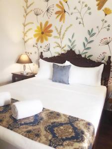 a bedroom with a bed with a flower wallpaper at Blue Waters Inn Coron Palawan in Coron +2 photos