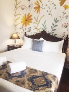 a bedroom with a bed with a flower wallpaper at Blue Waters Inn Coron Palawan in Coron